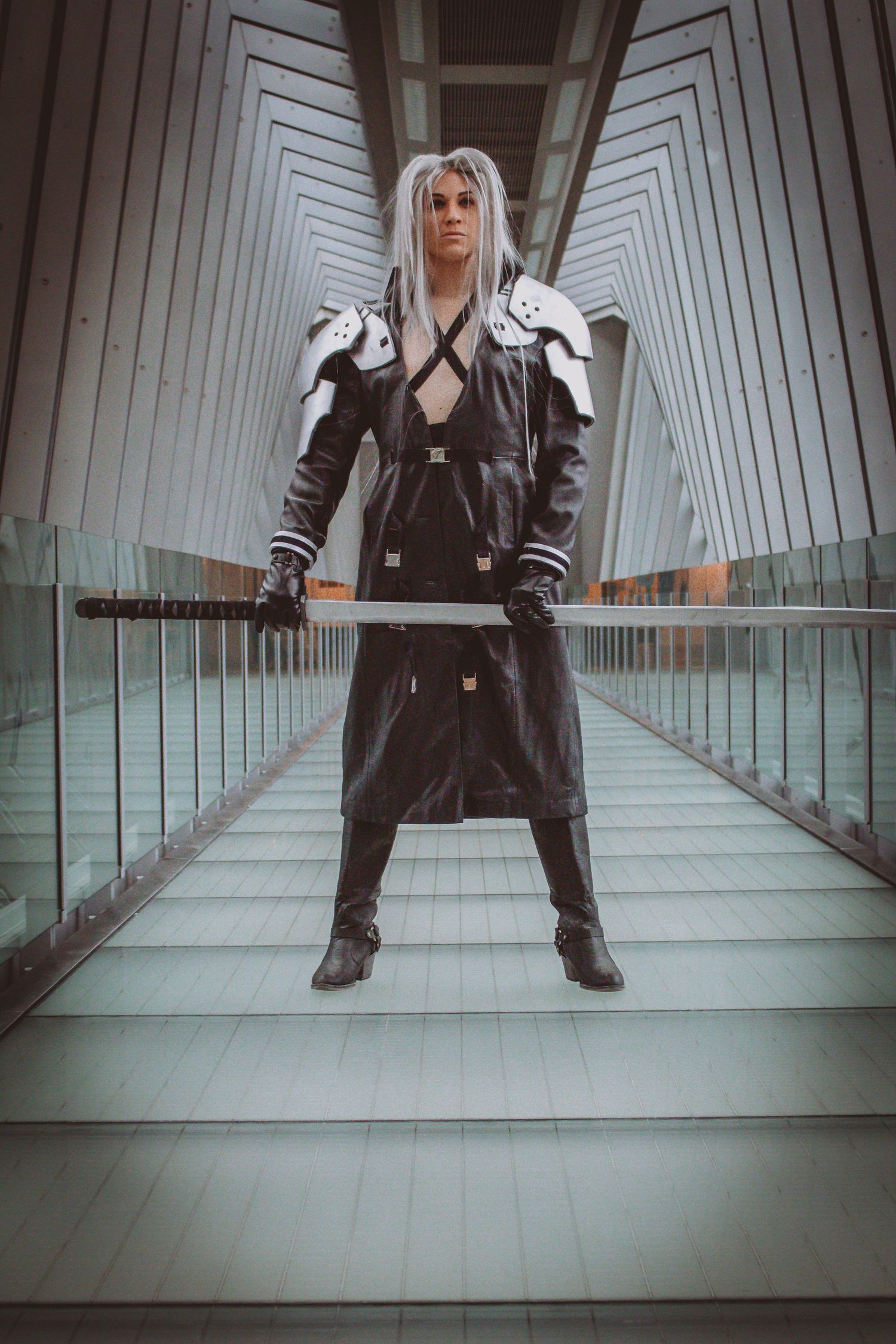Modern architectural hallway with symmetrical lines serves as backdrop for edgy fashion photography.