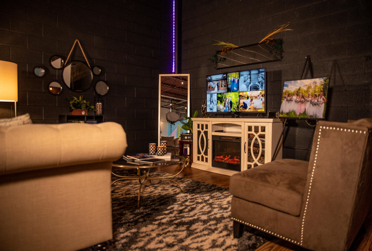 A cozy home theater setup with plush seating, ambient lighting, and multiple screens displaying entertainment content.