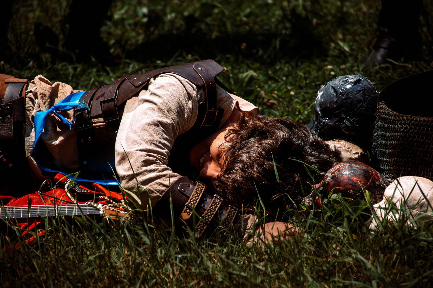 People lying on grass in a park during a sunny day.