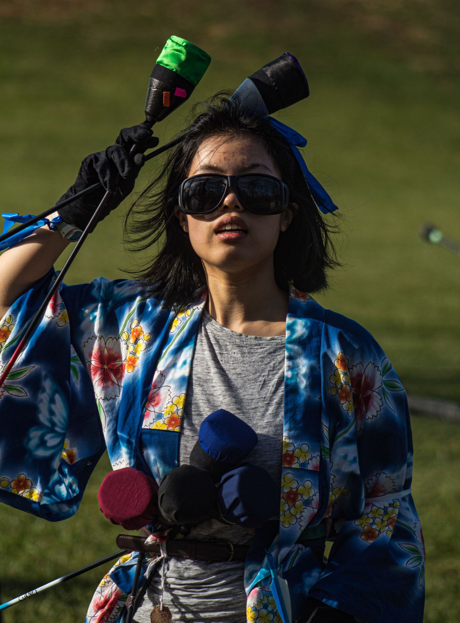 Person in colorful patterned jacket and sunglasses posing outdoors.