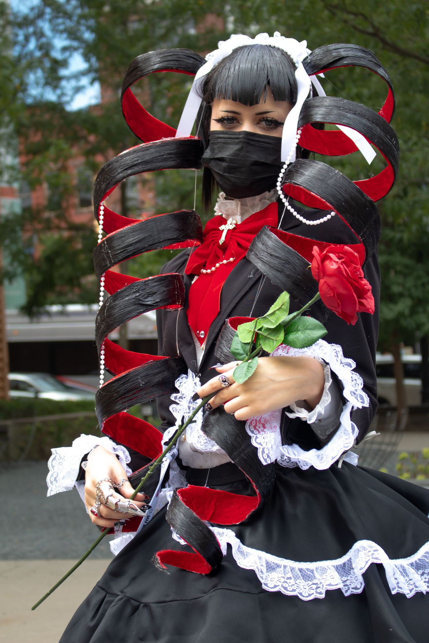 Gothic lolita fashion costume with black dress, red accents, and white lace details.