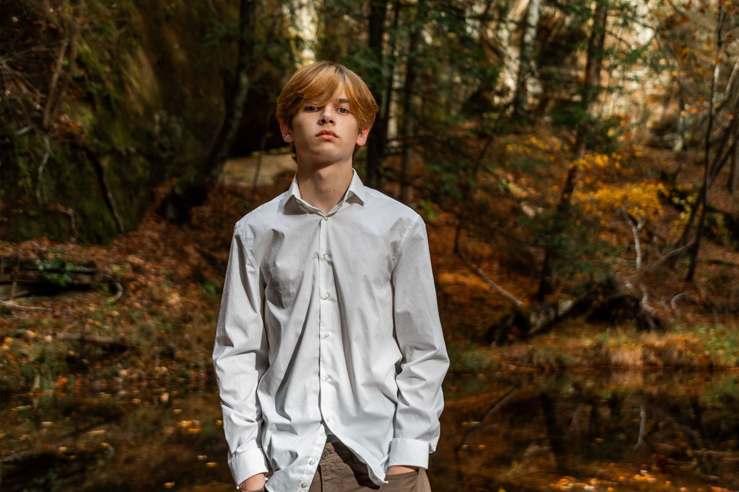 Portrait session in wooded area with autumn colors and natural lighting.