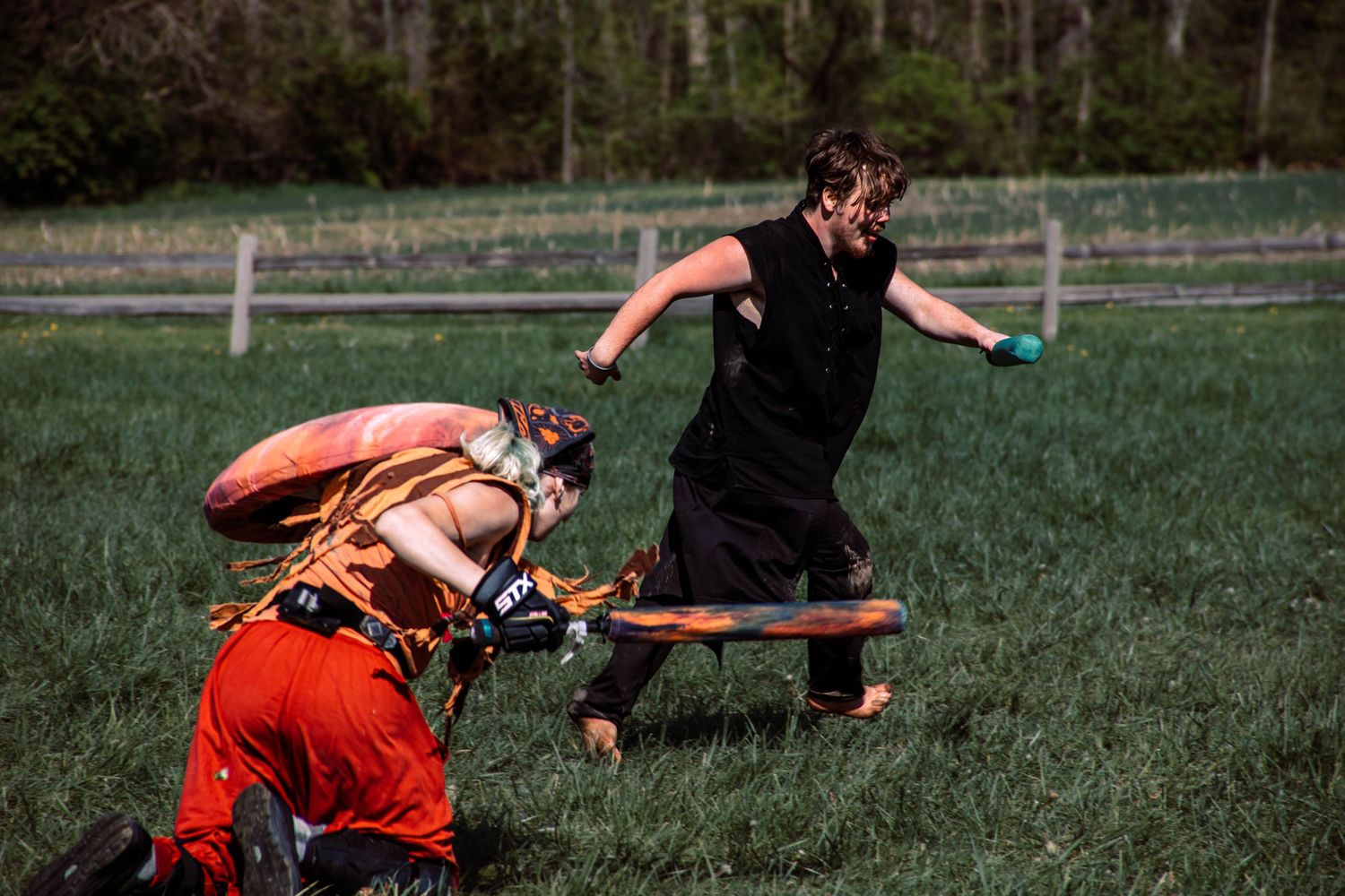 Soccer players engage in an intense sliding tackle during a competitive match on a grass field.