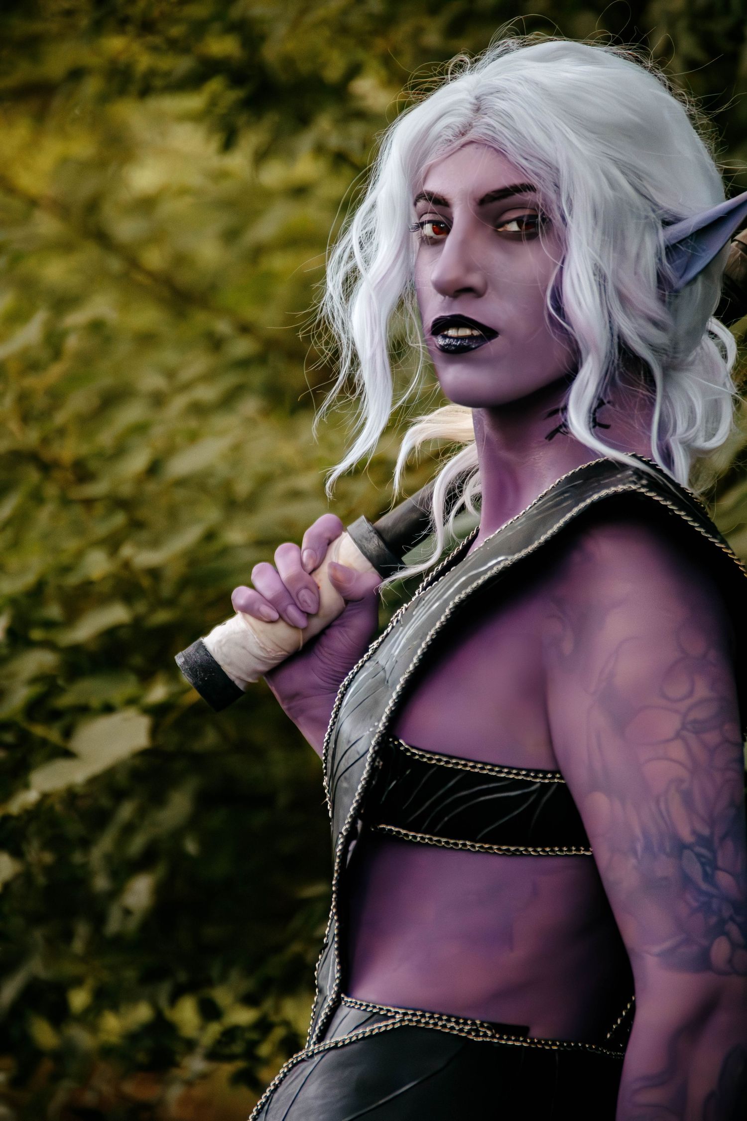 A cosplay character with white hair and dark makeup poses in a series of dramatic expressions against a blurred background.