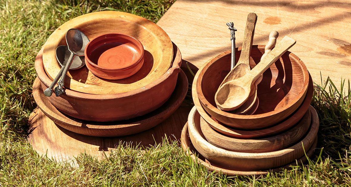 Terracotta plant saucers arranged in a row on grass showing different sizes and stacking configurations.