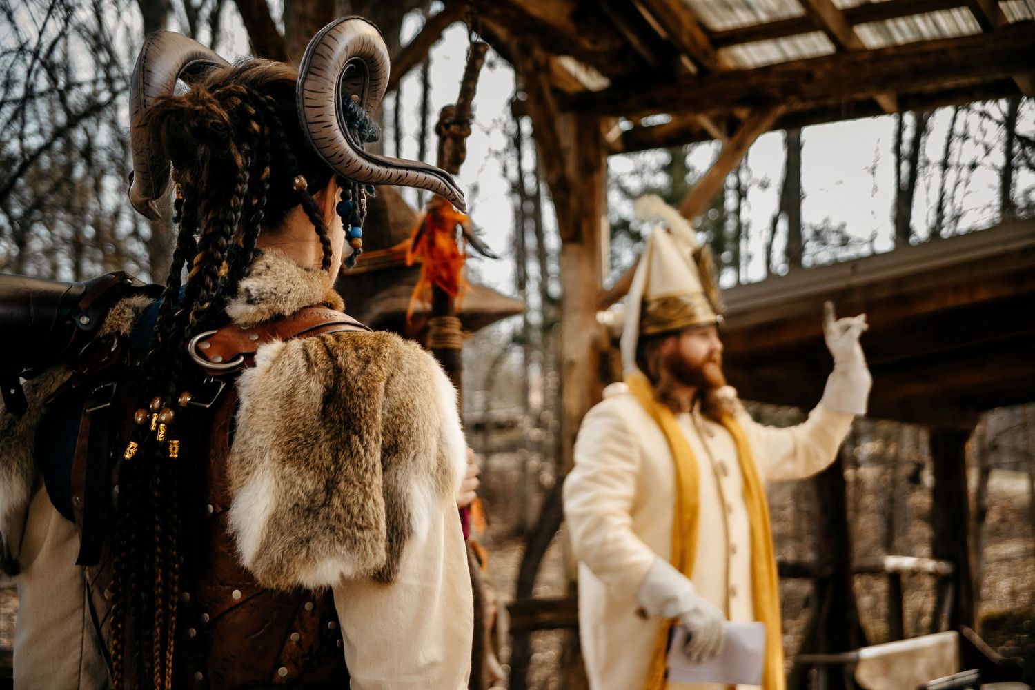 Winter fashion scene at rustic wooden gazebo with fur coat and yellow jacket in outdoor setting.
