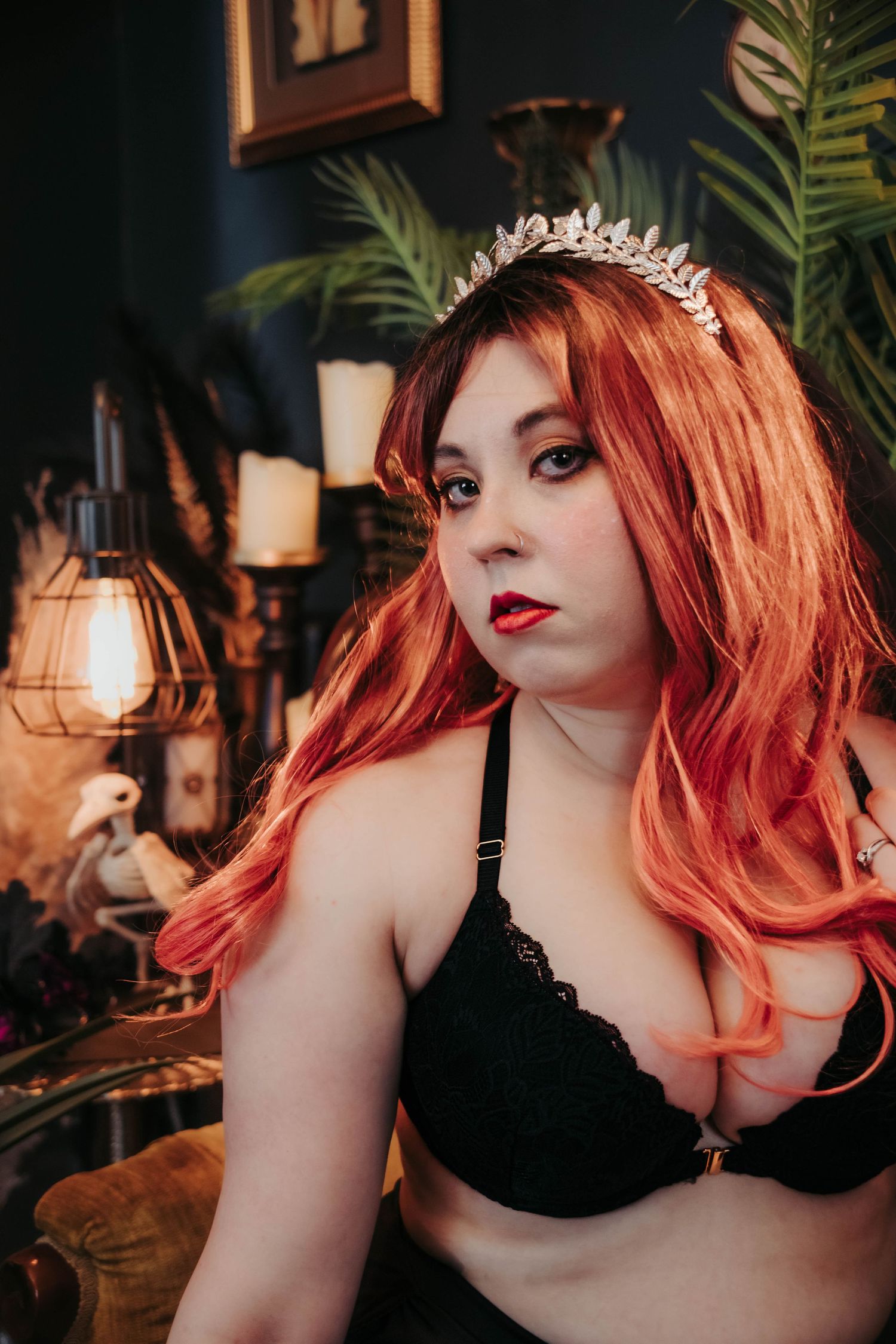 Boudoir photo series featuring red hair and black lingerie in moody indoor lighting with palm plants in background.