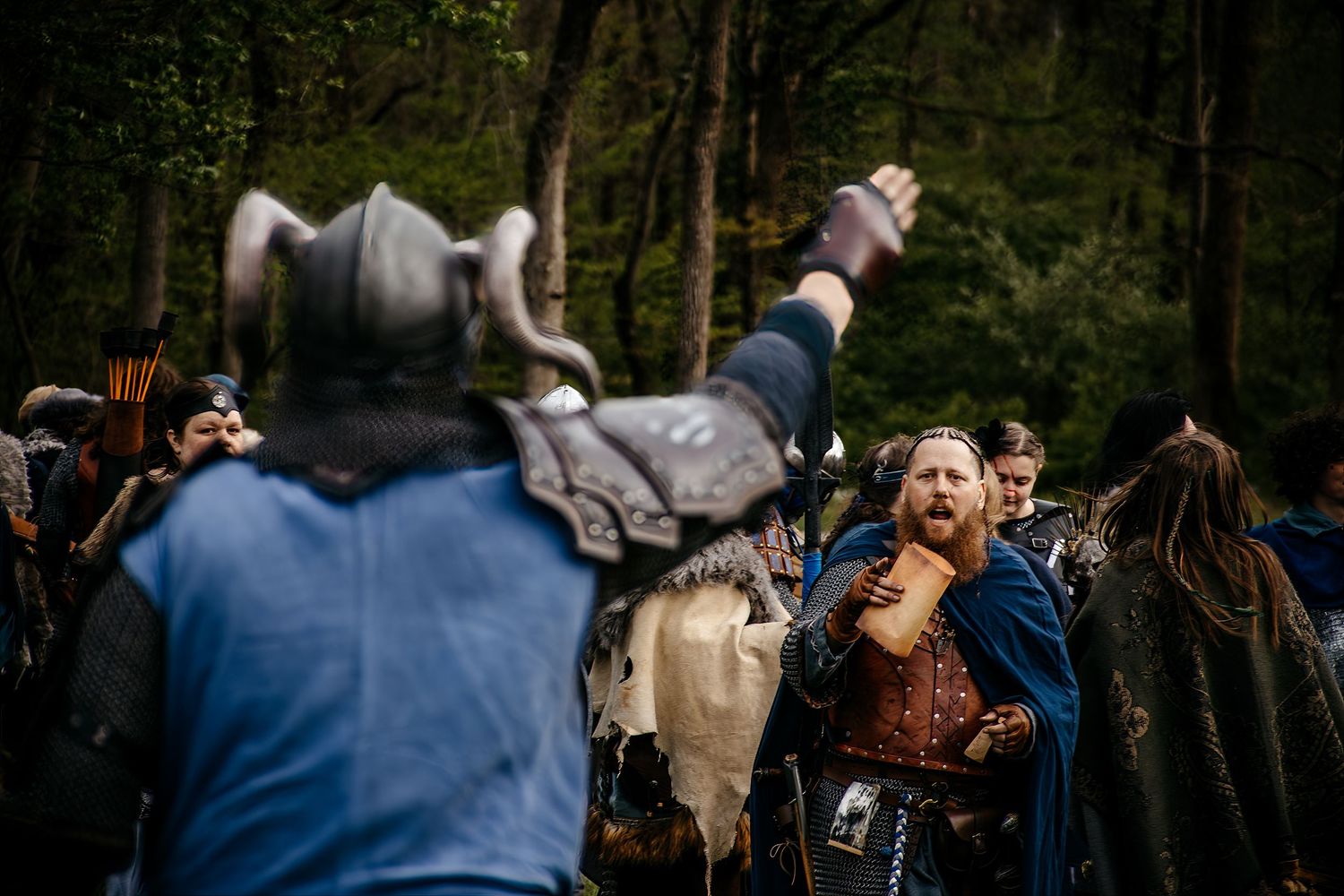 Medieval Viking reenactors in costume battle in a forest setting during a historical LARP event.