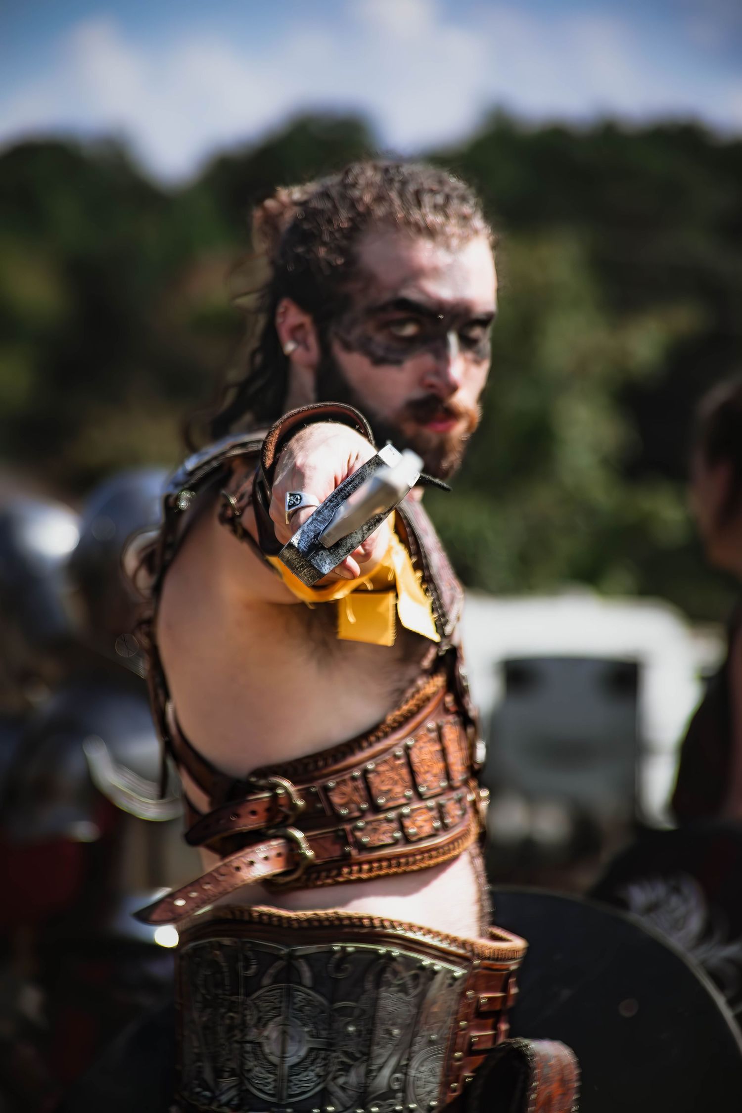 A series of close-up photos showing a leather corset being laced up with intricate details and brass hardware.