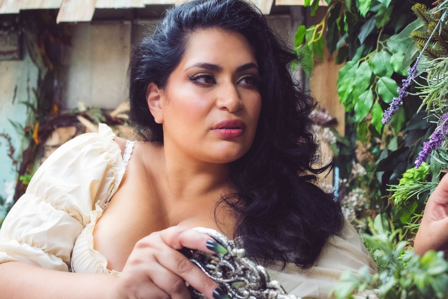 Ethereal nature photoshoot with flowing dress among garden foliage.