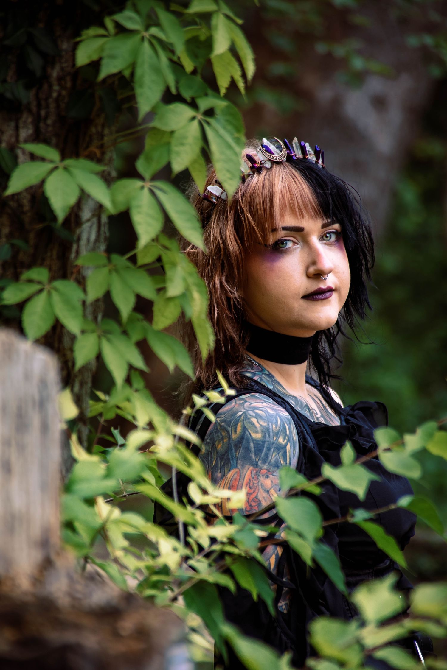 Gothic styled portrait among green leaves and natural foliage.