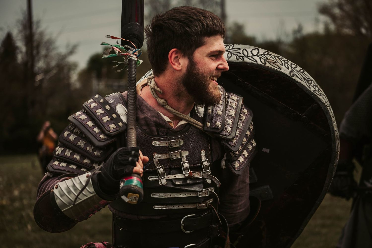 Medieval warriors in chainmail and leather armor gather at a historical reenactment event.