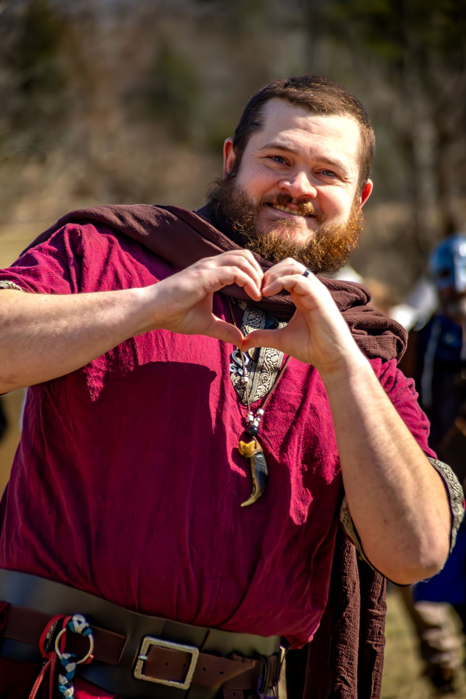 A sequence of photos shows someone in a burgundy shirt making a heart shape gesture with their hands.
