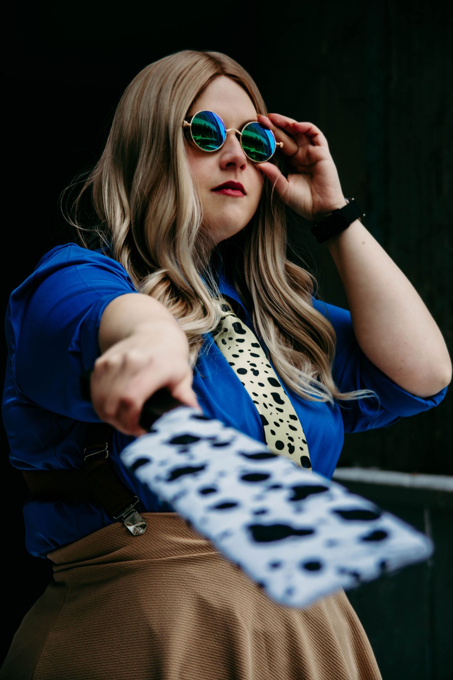 A fashion portrait series showing a woman in blue and tan clothing with sunglasses posing against a dark background.