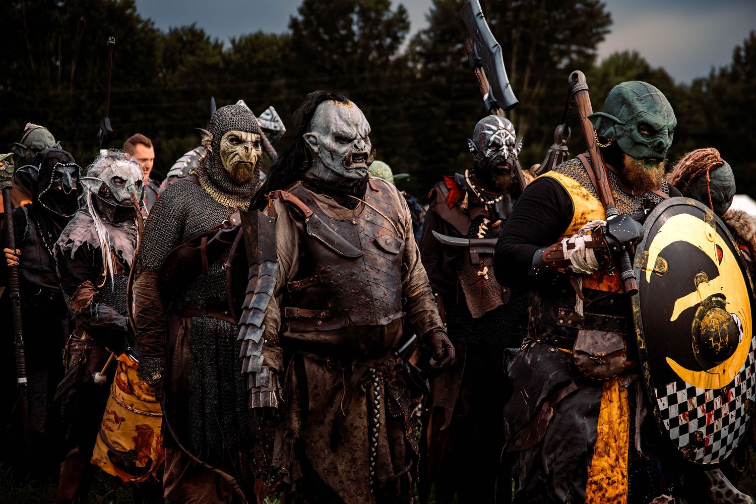 Medieval knights and warriors in detailed armor and costumes gather at a historical reenactment event.