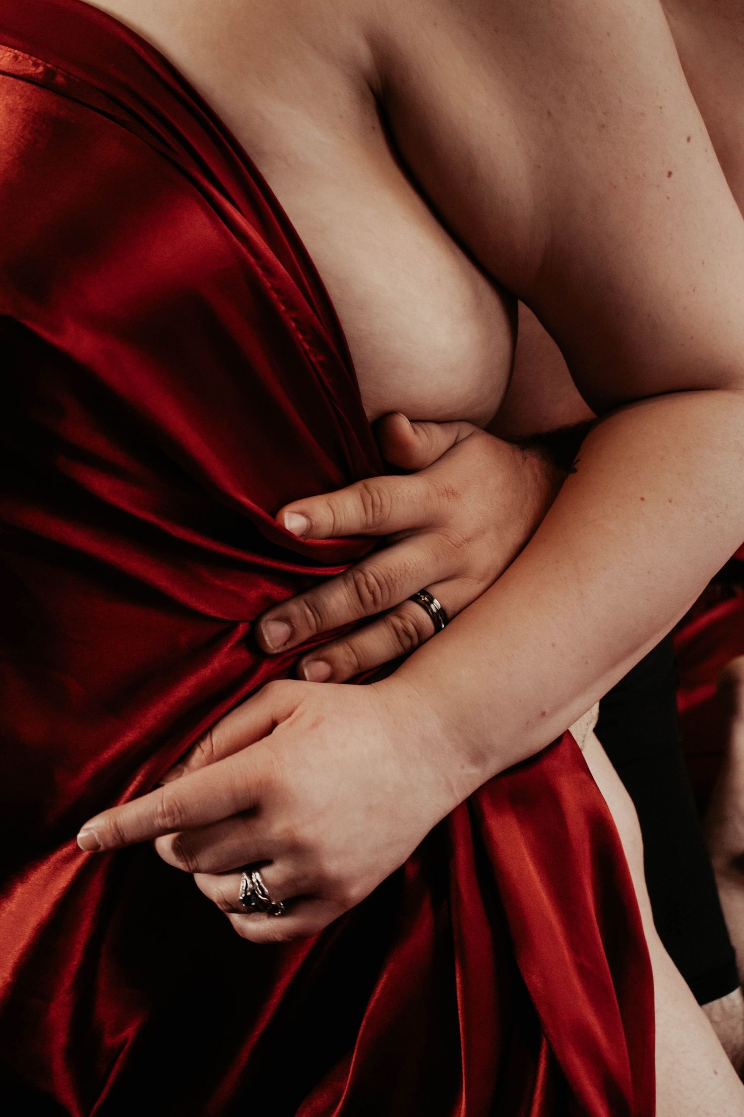 Intimate artistic photo with red silk fabric draping.