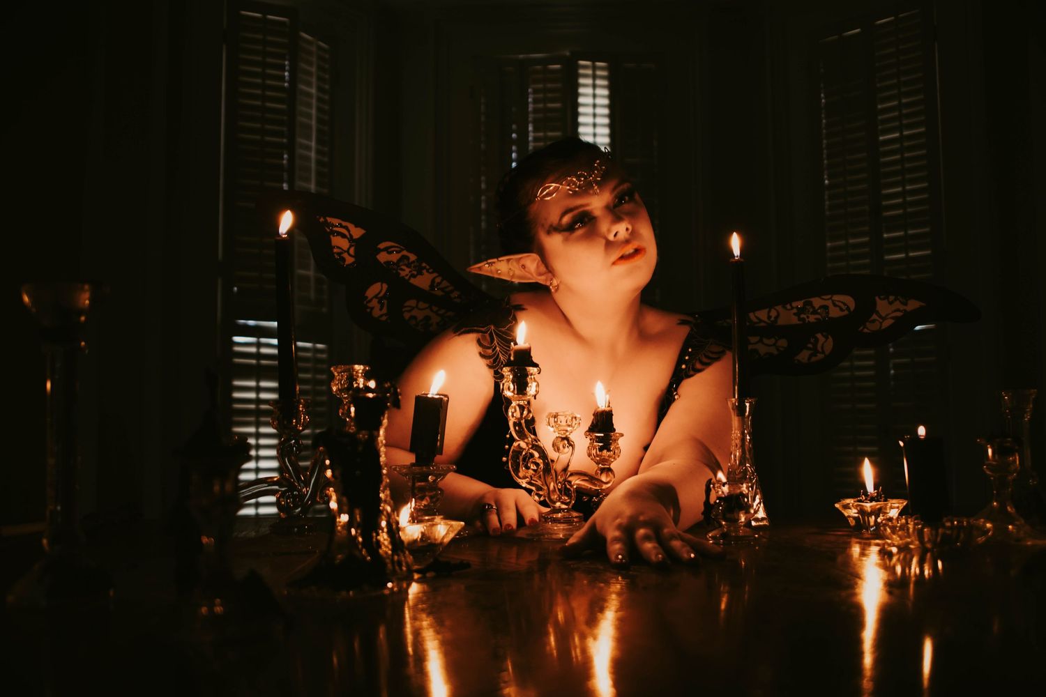 A dark and moody candlelit scene with multiple candles casting warm glows in a dimly lit room.