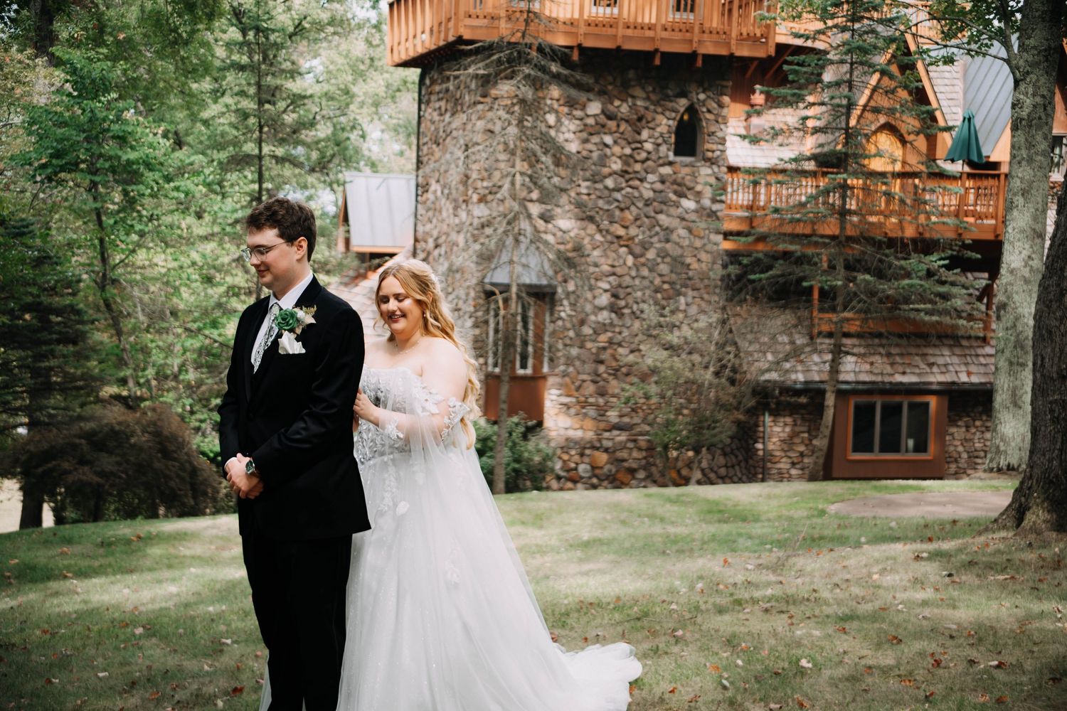 A romantic wedding couple shares tender moments together in front of a rustic stone building on their special day.