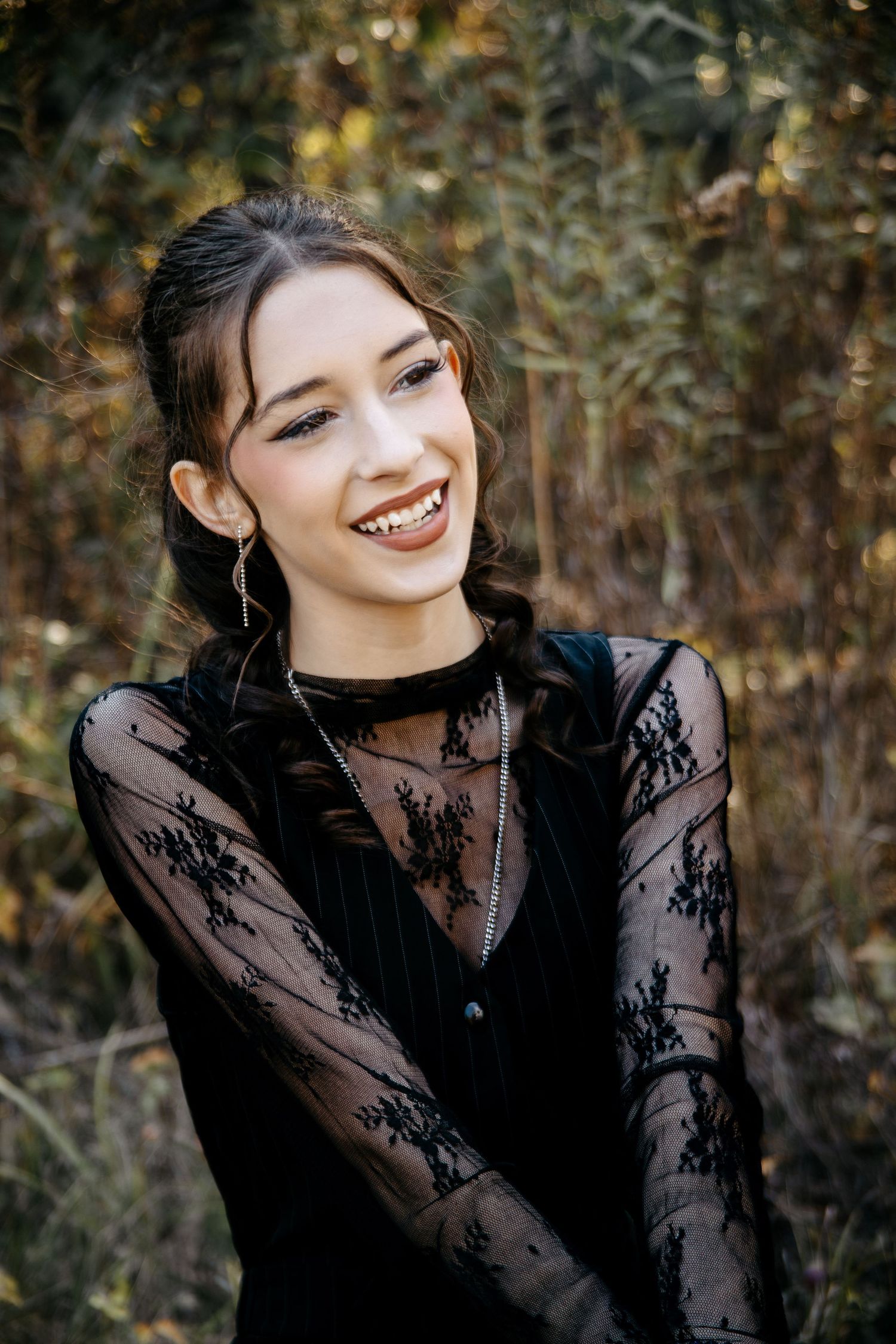 Portrait series in black lace dress against autumn forest backdrop.