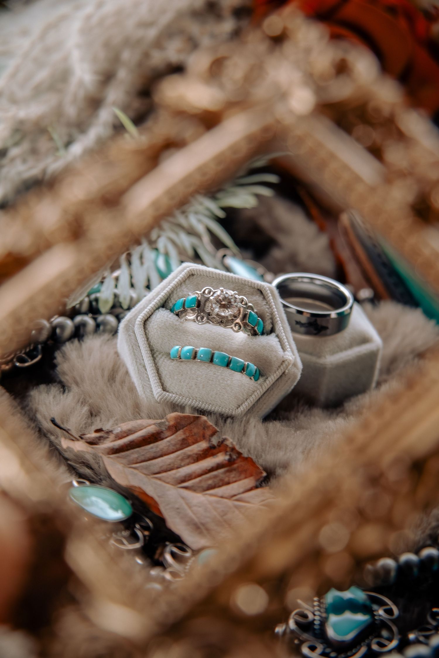 Turquoise and silver wedding rings displayed in hexagonal ring boxes with Native American inspired styling.
