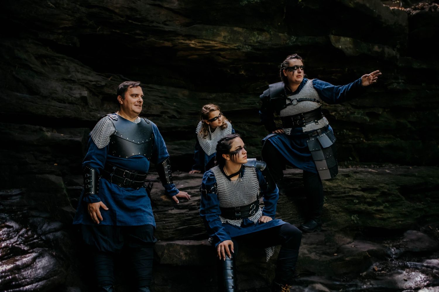 Friends laughing together on rocky terrain in casual outdoor clothing.