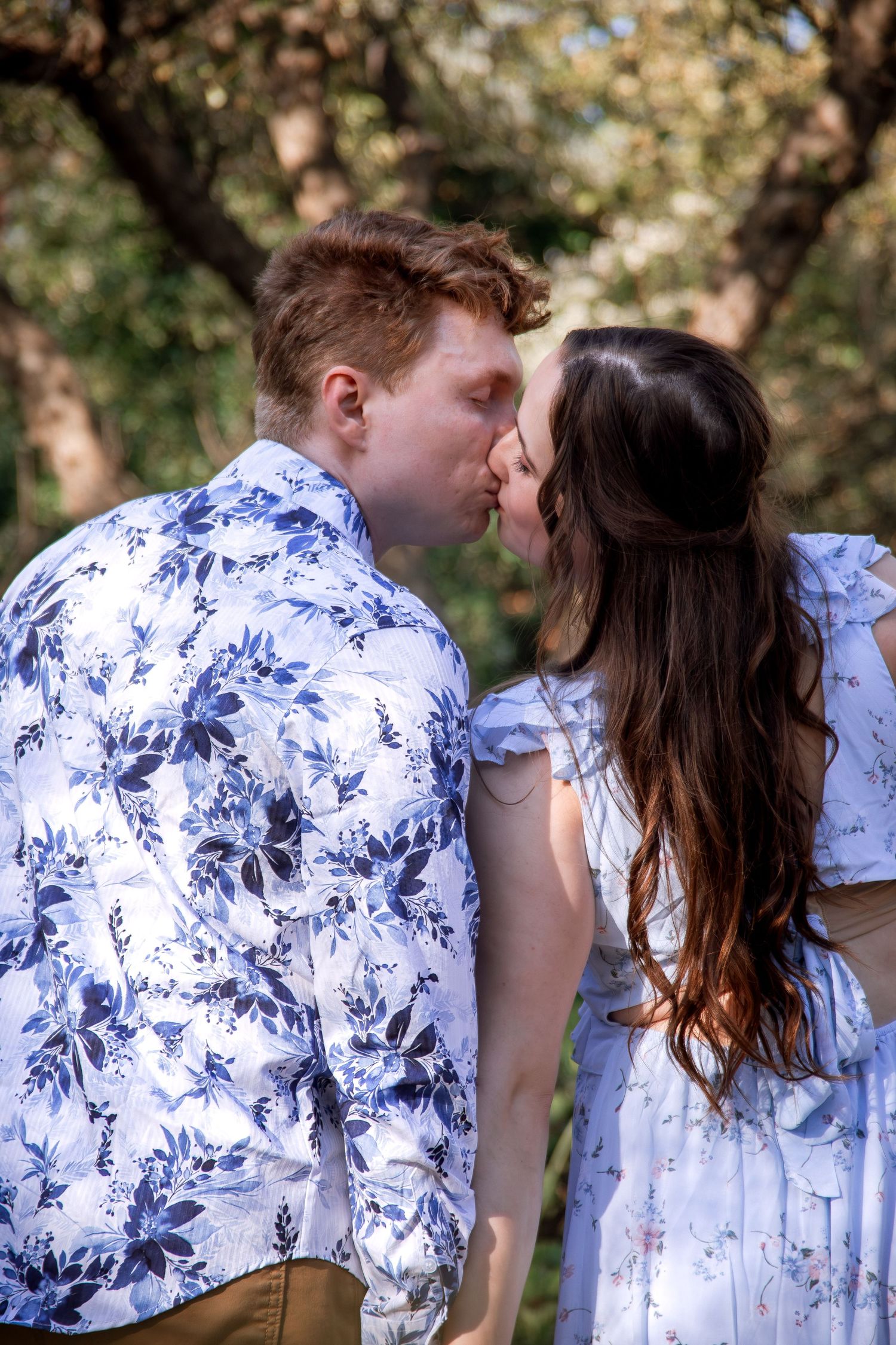 Intimate portrait session featuring couple in matching floral print outfits outdoors.