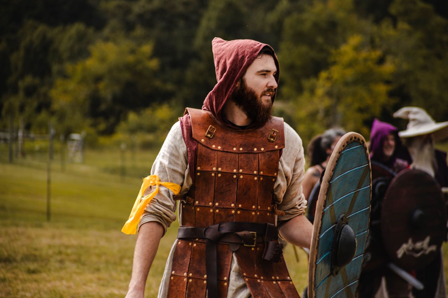 Detailed view of brown leather medieval armor with brass studs and decorative patterns.