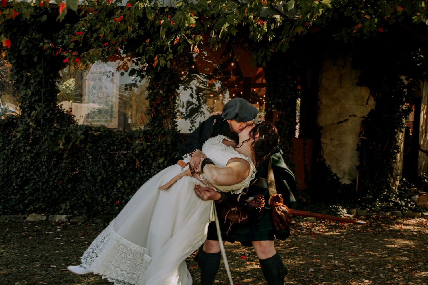 Romantic wedding couple poses in a wooded area with dramatic lighting.