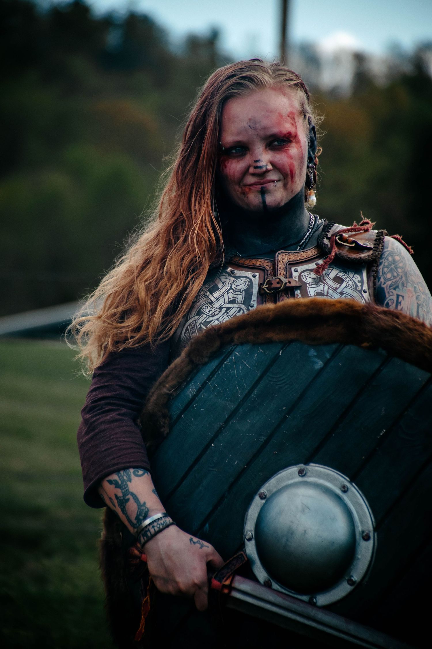 A series of five images showing someone in medieval Viking warrior costume with face paint and armor holding a shield.
