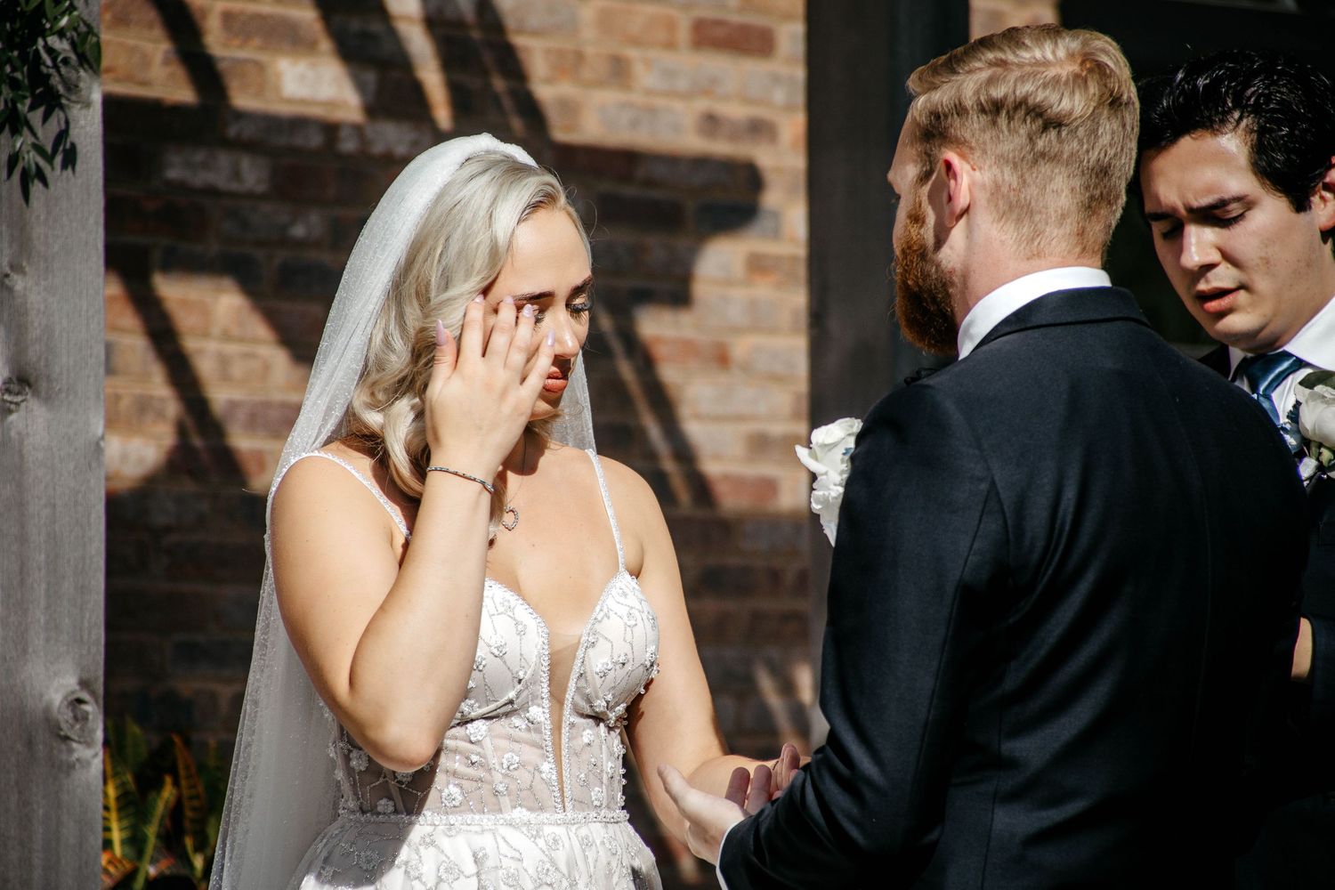 Intimate wedding portraits taken against rustic brick architecture.