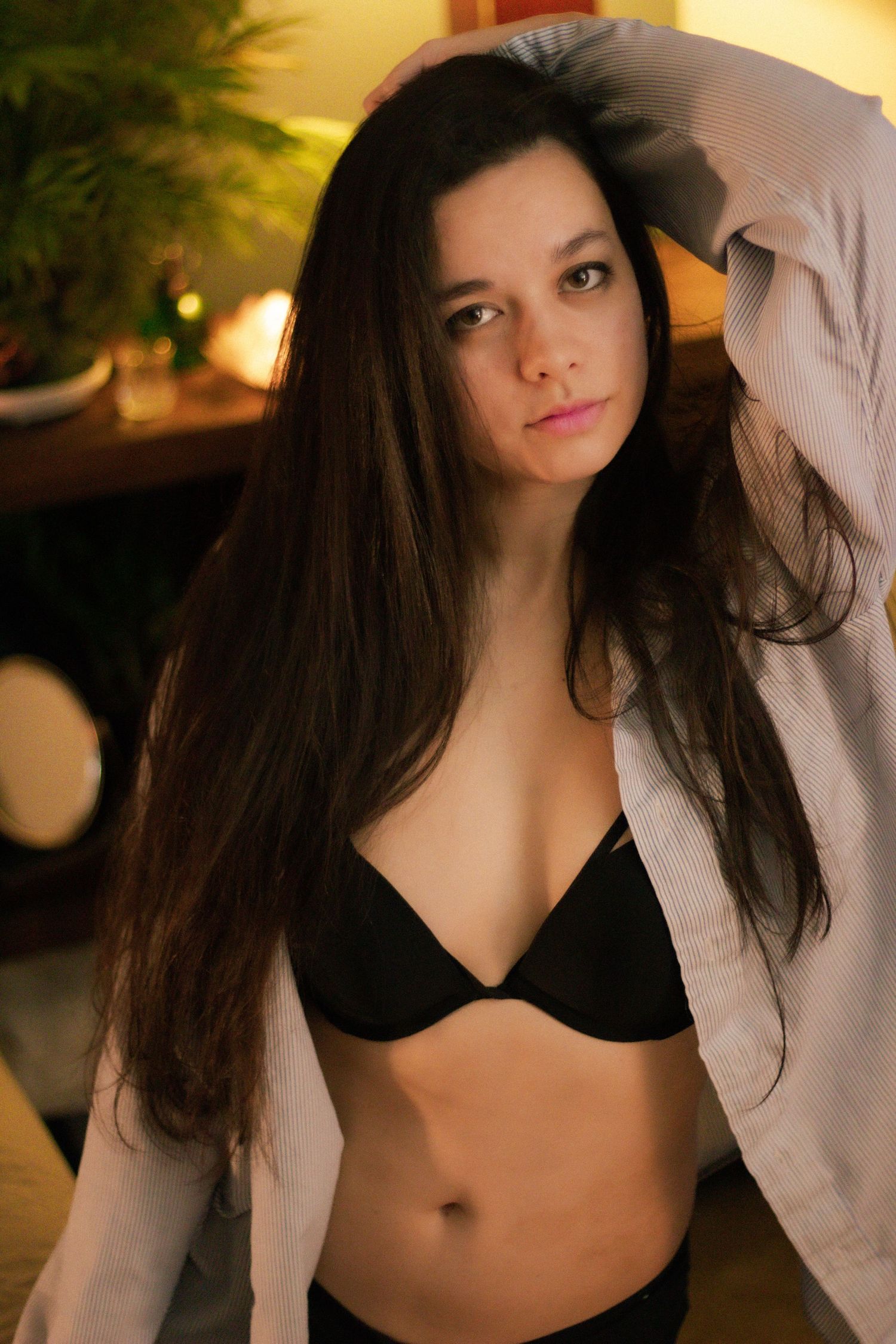 Sensual boudoir photography with warm golden lighting and casual styling.