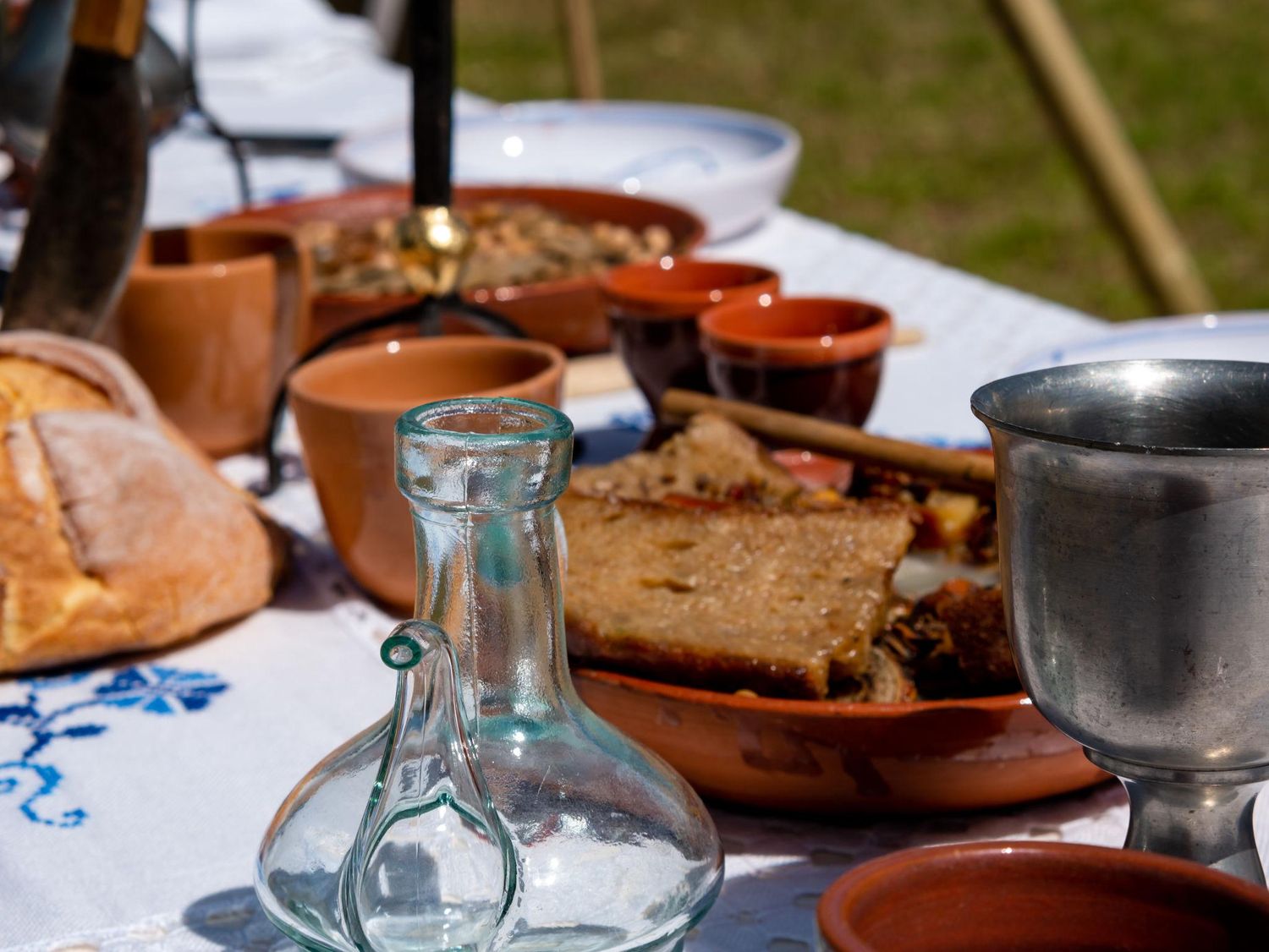 A rustic outdoor table setting with ceramic plates and glasses arranged for a casual dining experience.