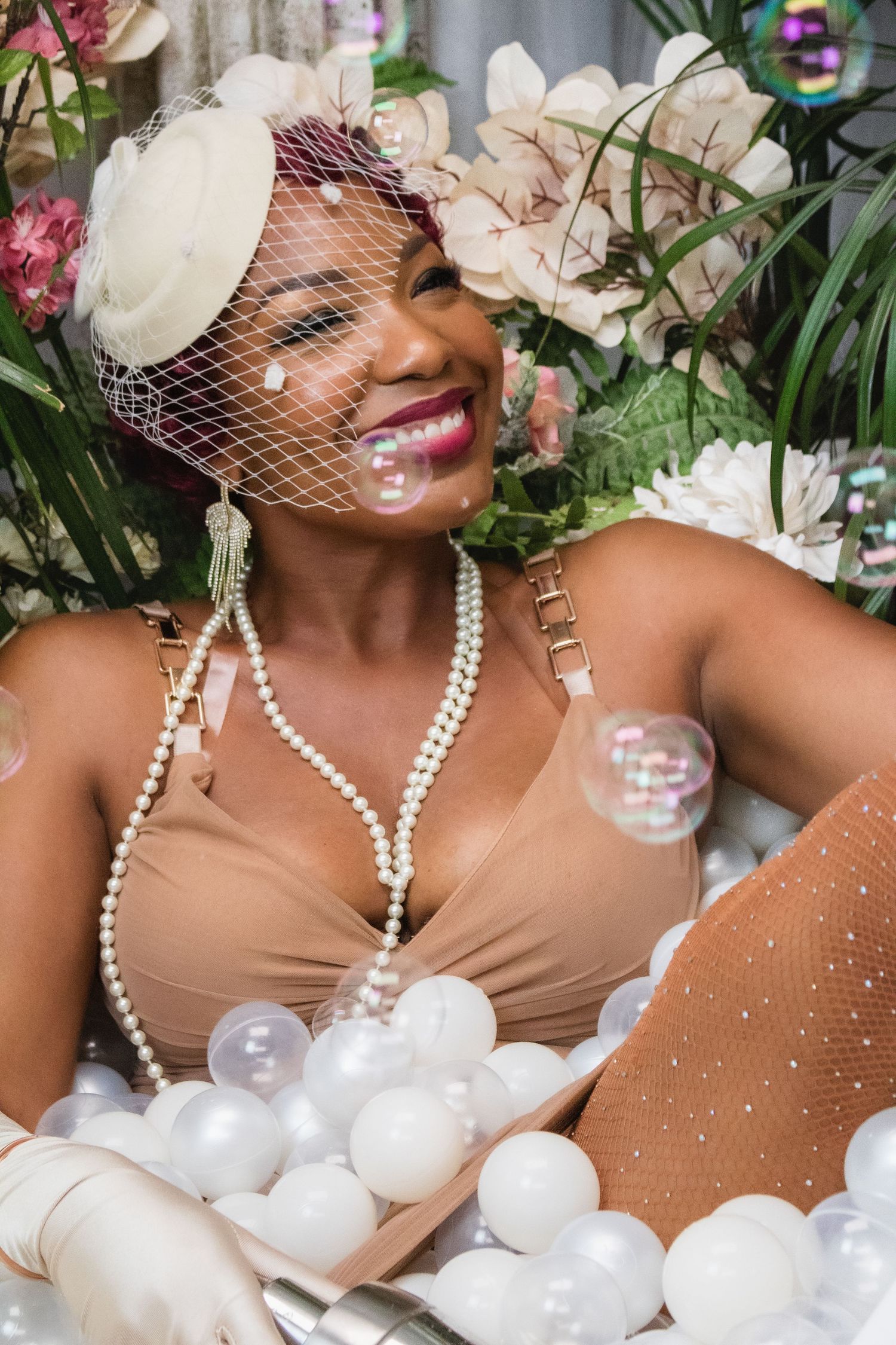 Glamorous bathtub photoshoot featuring pearls, bubbles and elegant vintage-inspired styling.