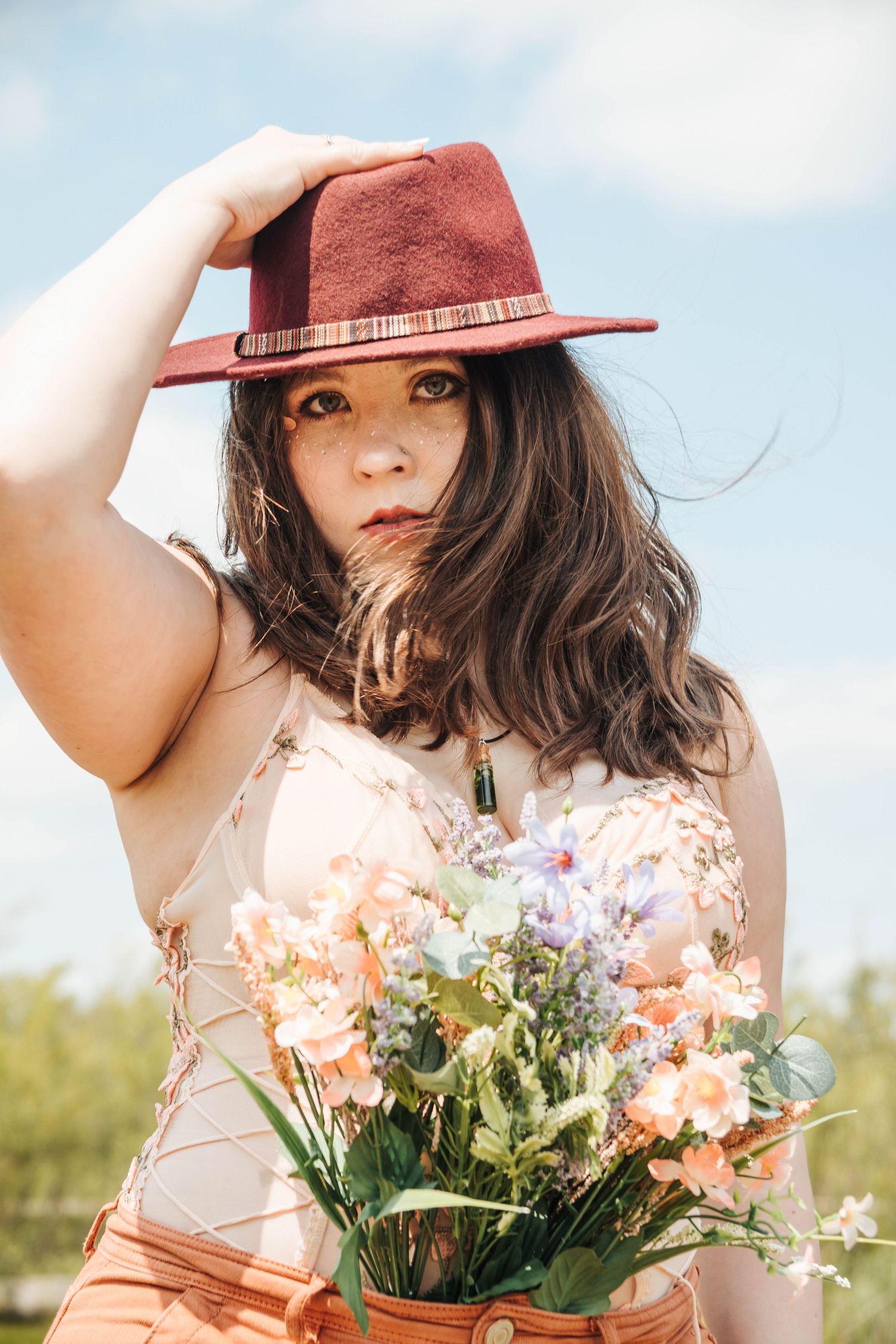 A series of photos showing someone in a brown hat holding a bouquet of peach roses and white flowers in natural sunlight.