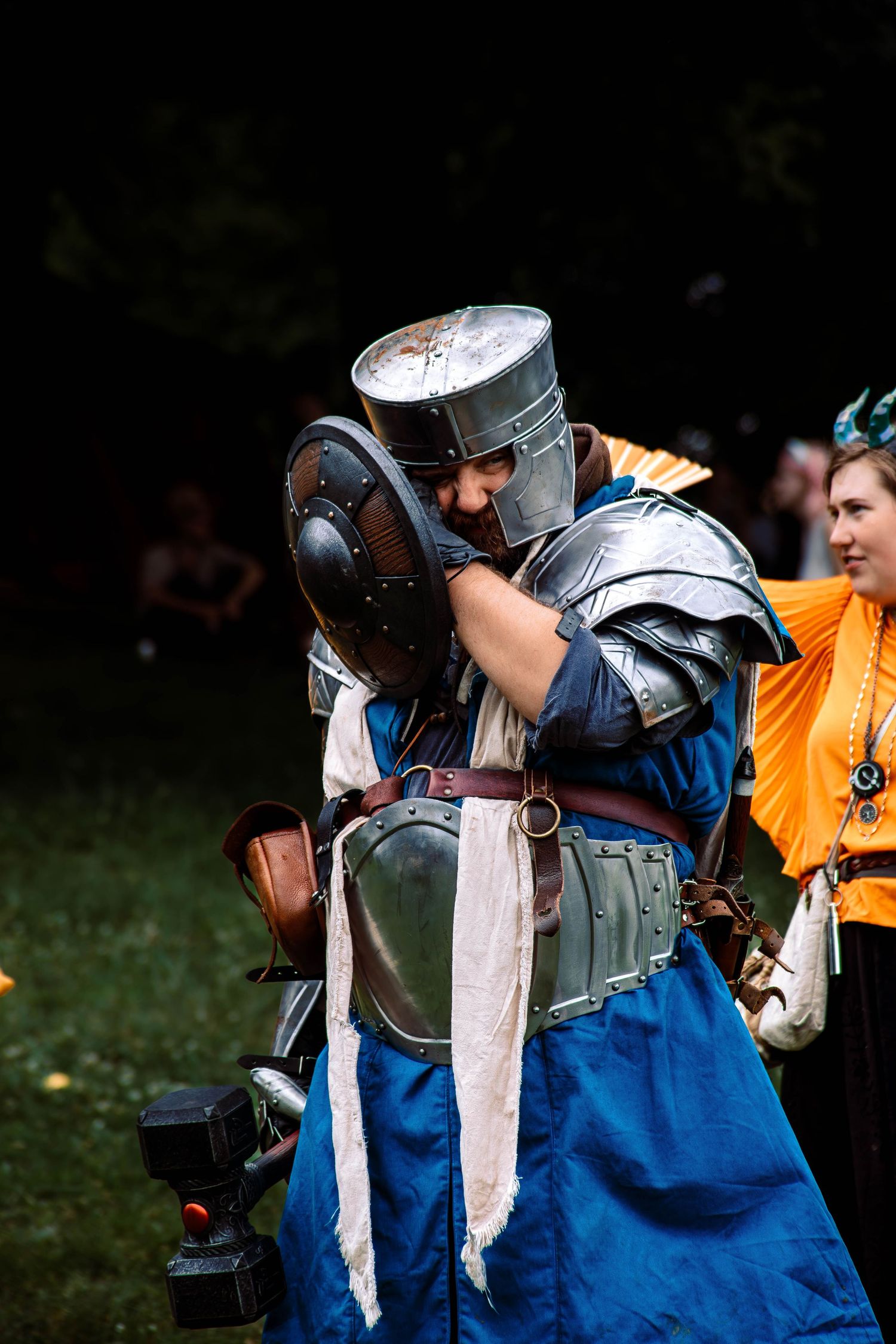 Medieval fighters in blue tunics and helmets preparing for combat.