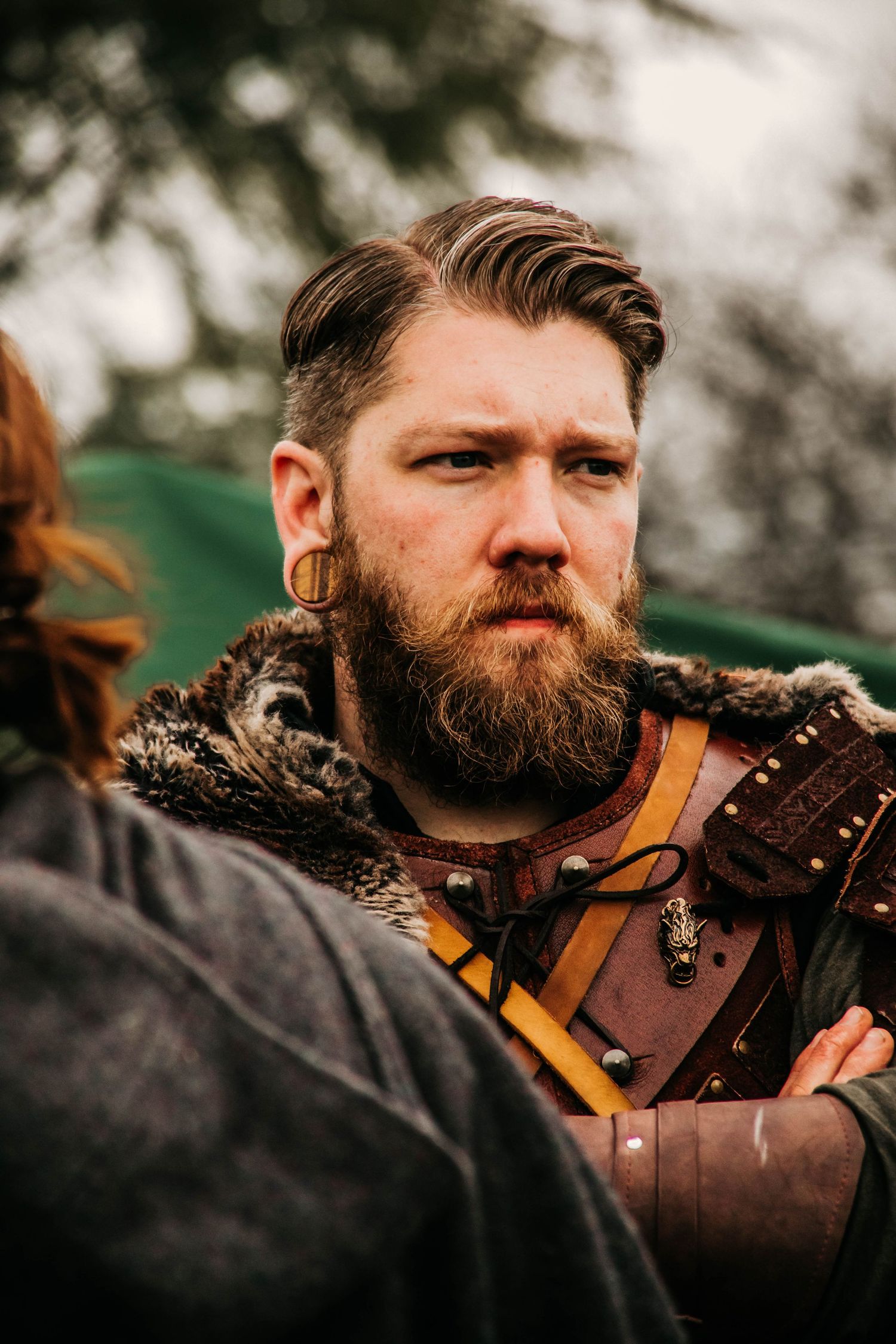 A series of close-up shots showing a bearded person in medieval costume with leather armor and decorative details.