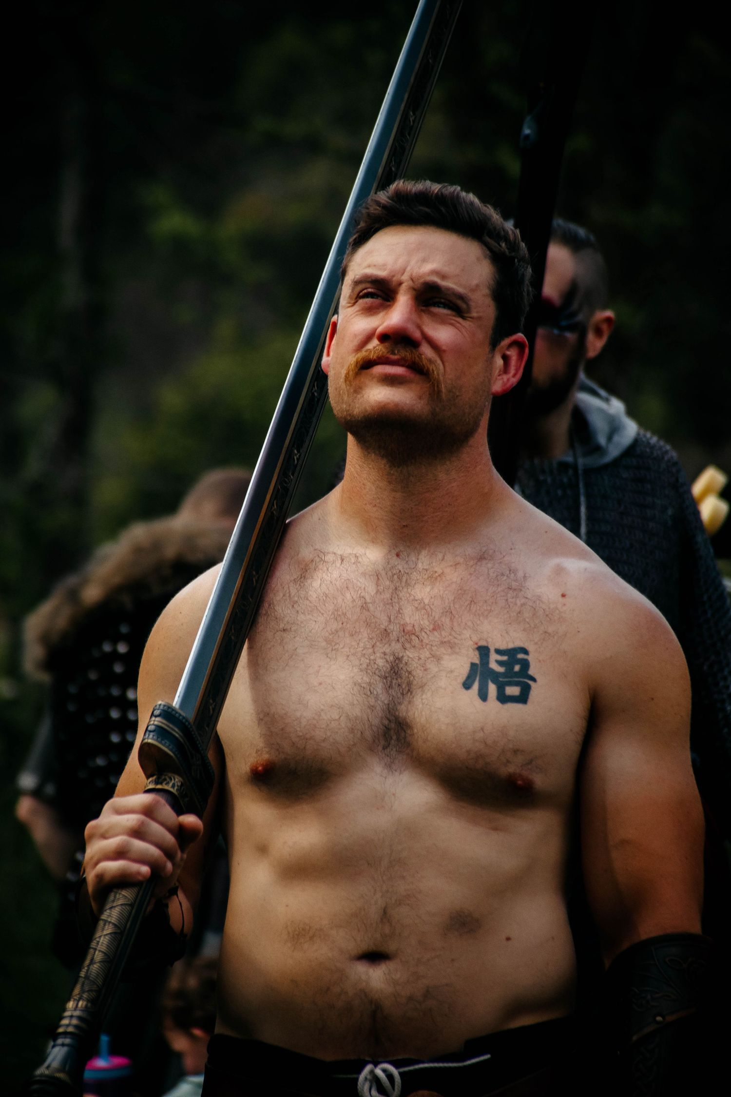 A shirtless person holding a rifle poses in a sequence of photos with a smirking expression.