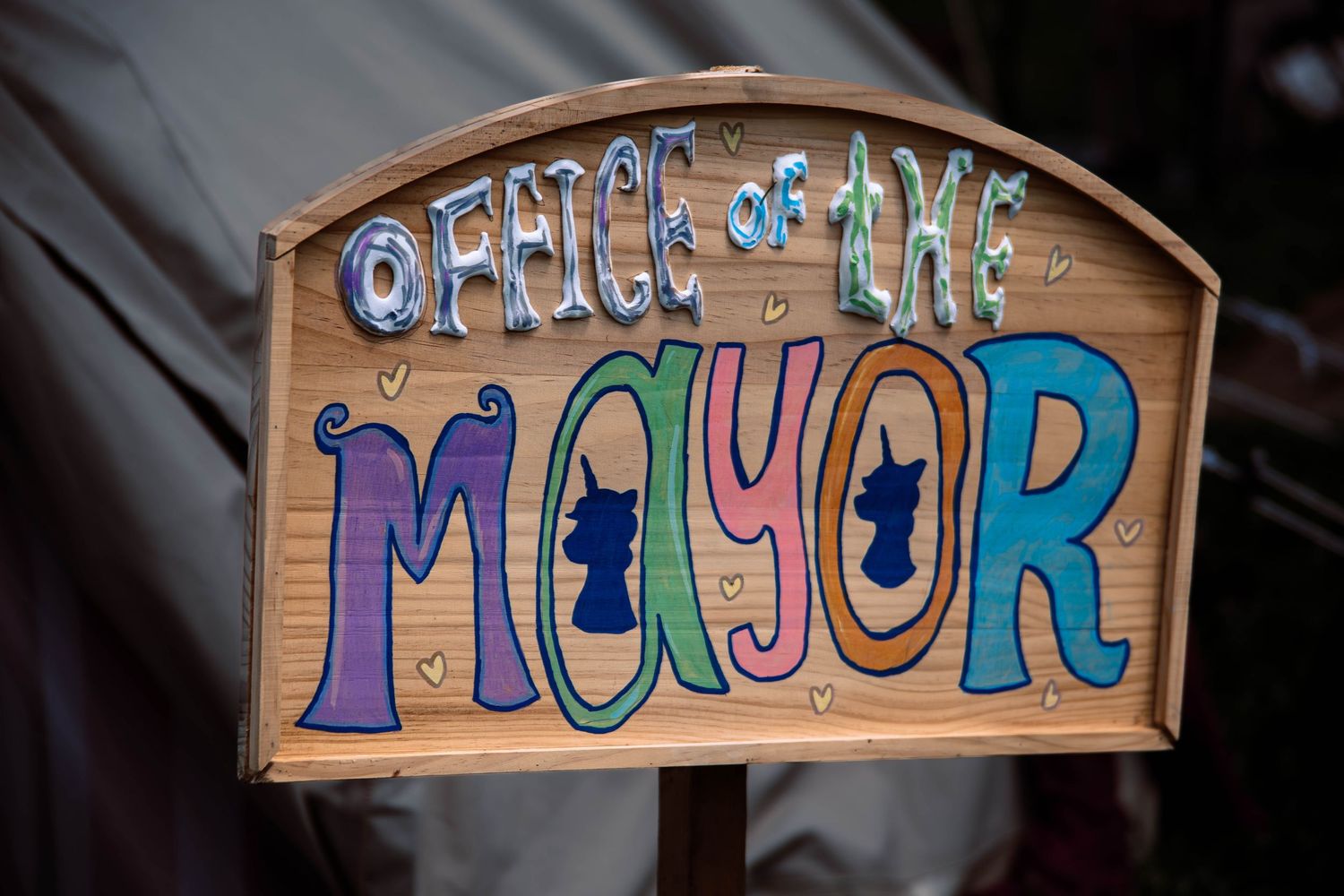 Colorful wooden signs with whimsical lettering spelling out different words mounted on a wall.