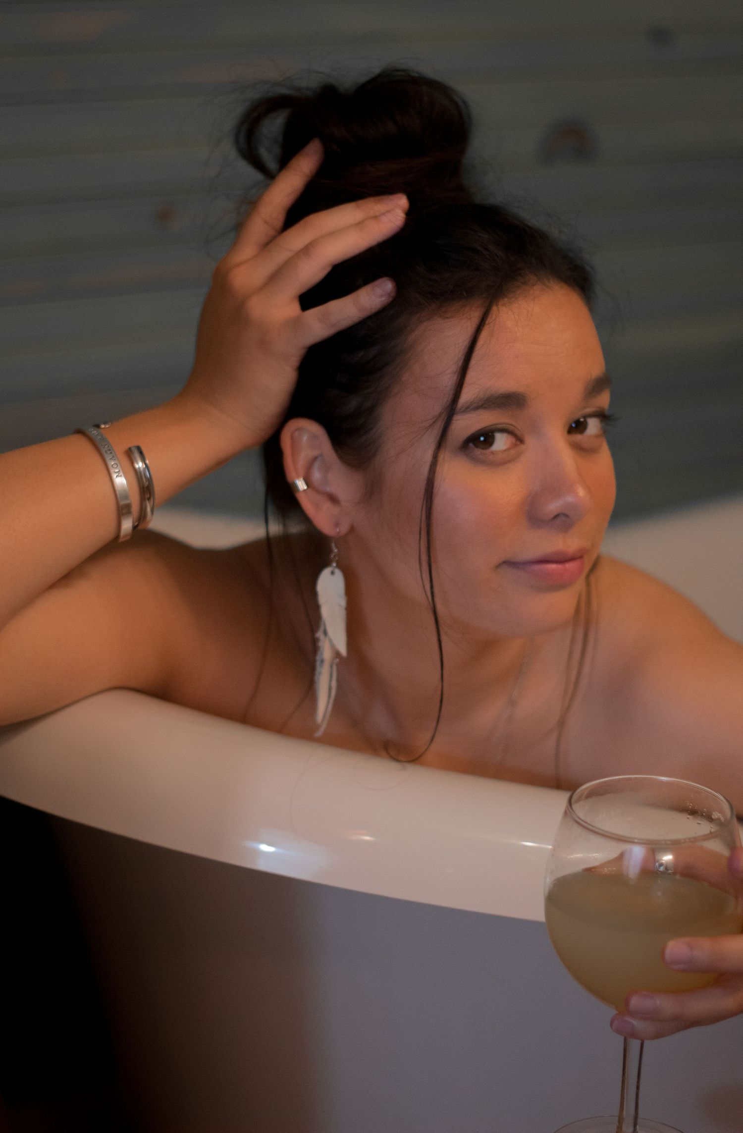 A person relaxes in a bathtub with a beverage, showing a sequence of candid moments during bathtime.