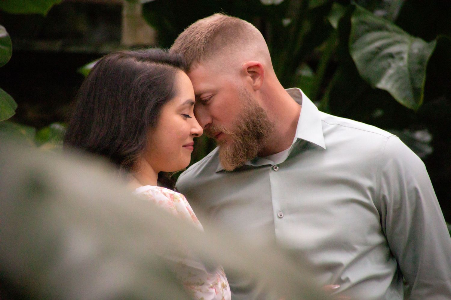 Intimate outdoor portrait session among green foliage and natural lighting.