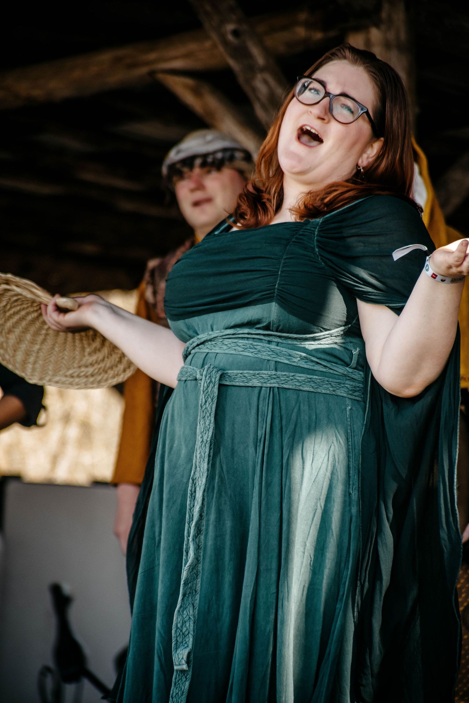 A sequence of photos showing someone in a teal dress laughing and dancing expressively at an indoor venue.