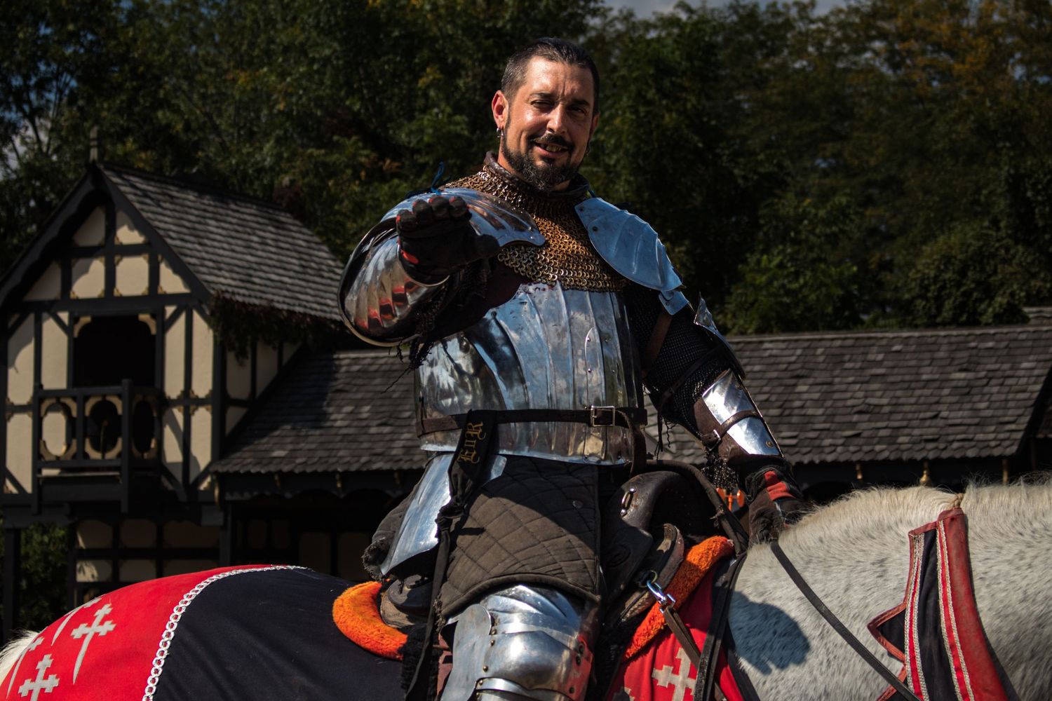 Medieval performers in red period costumes entertain at a renaissance fair.