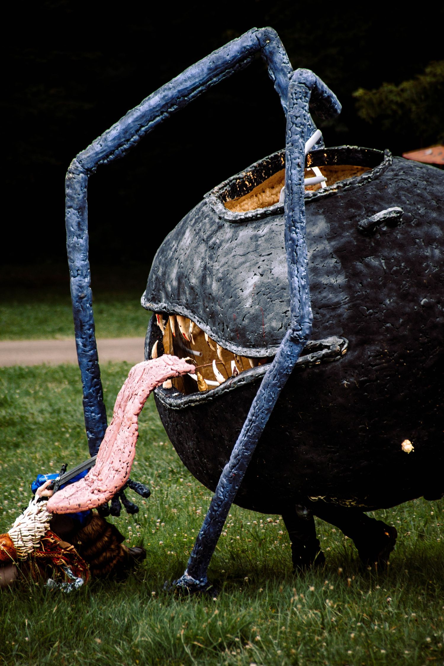 A sequence showing a black pinata being hit and bursting open with candy spilling onto grass during an outdoor party.
