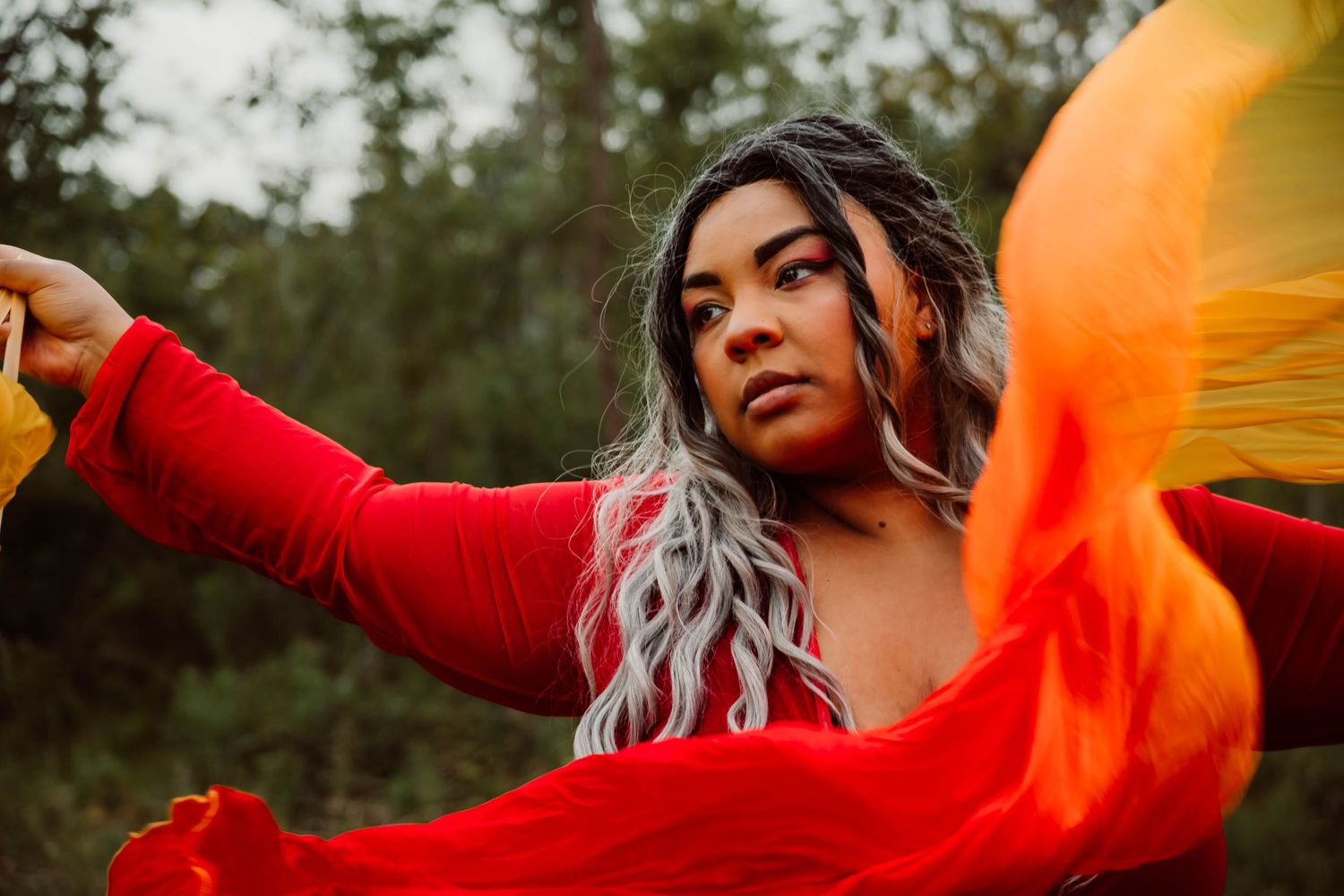 Vibrant outdoor portrait series with orange fabric flowing in the wind.