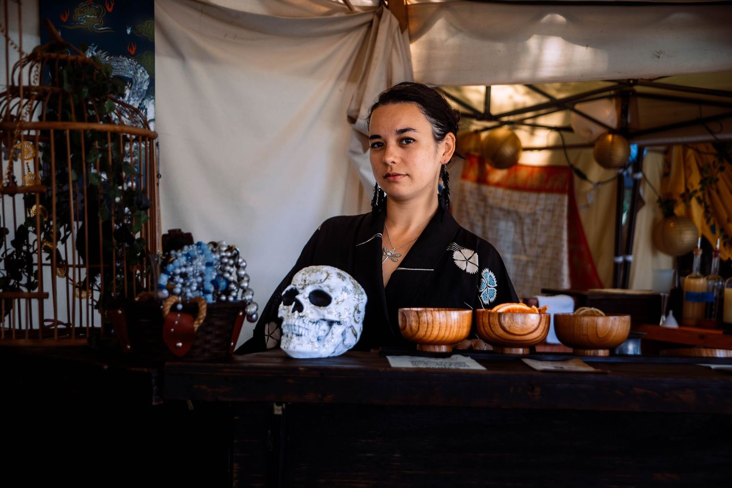 A decorated bar counter with a crystal skull, wooden bowls and moody lighting in a dark atmospheric setting.