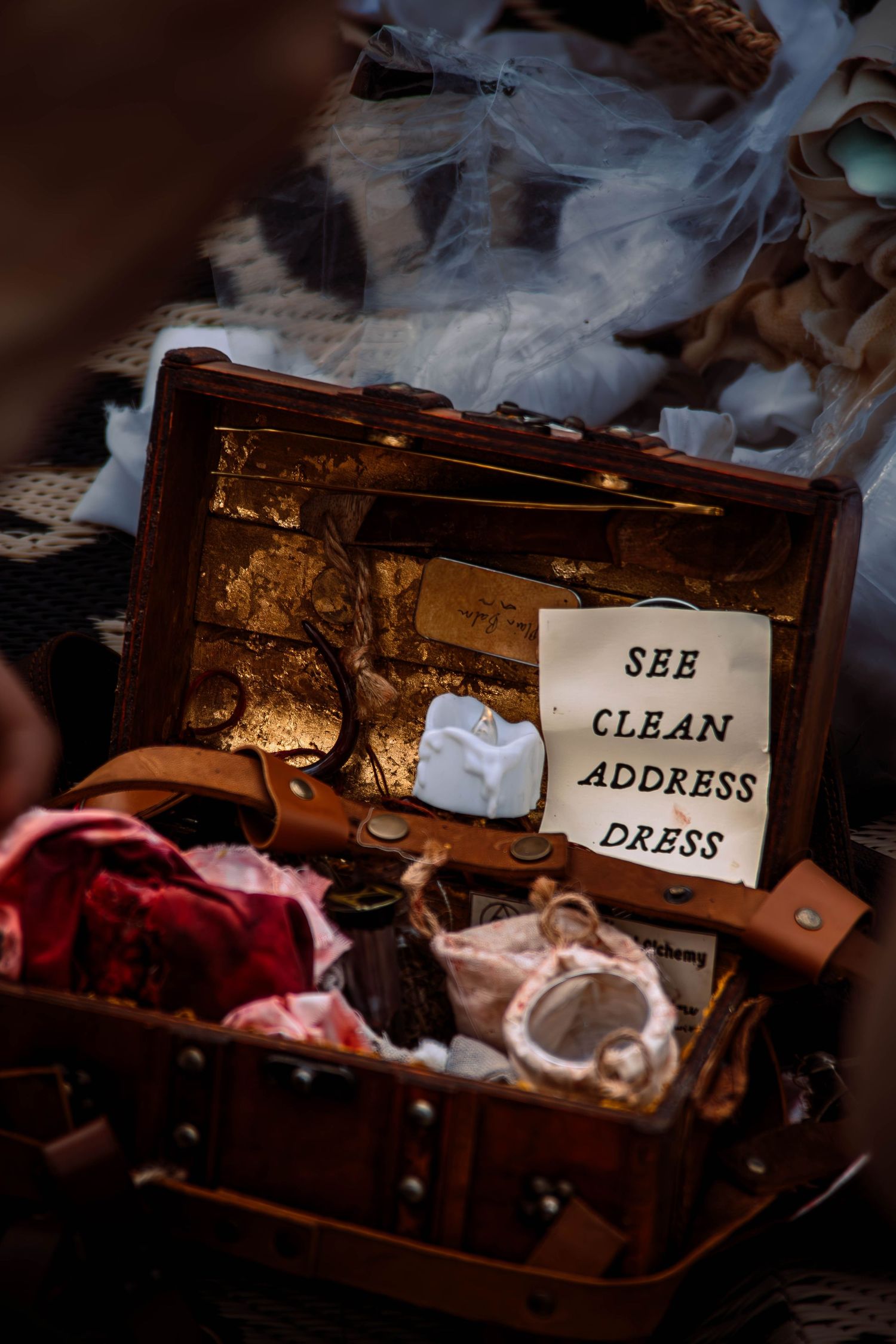 A vintage wooden chest with labels reading 'Address' and 'Clean' sits open with smoke or steam rising in dramatic lighting.
