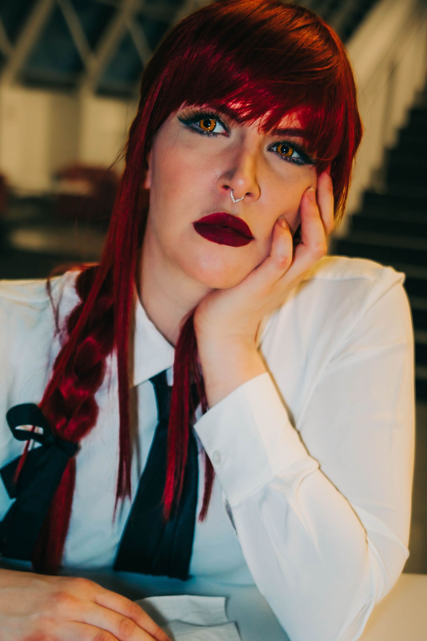A series of photos showing someone with vibrant red hair wearing a white shirt while resting their head on their hand.