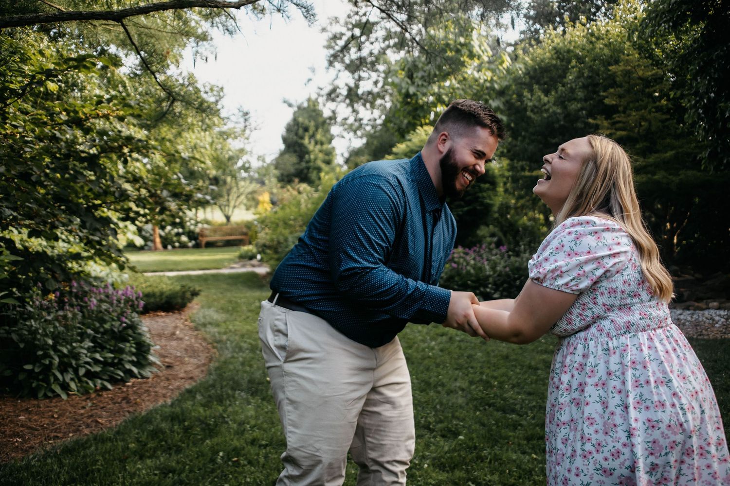 A couple shares tender moments together during an outdoor photo session in a natural green setting.