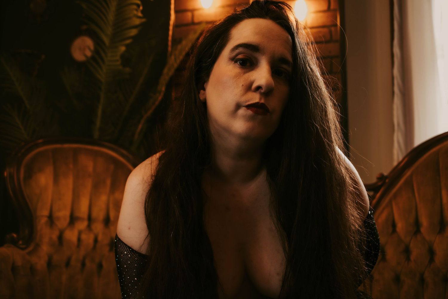 Intimate portrait session with vintage furniture and amber lighting.