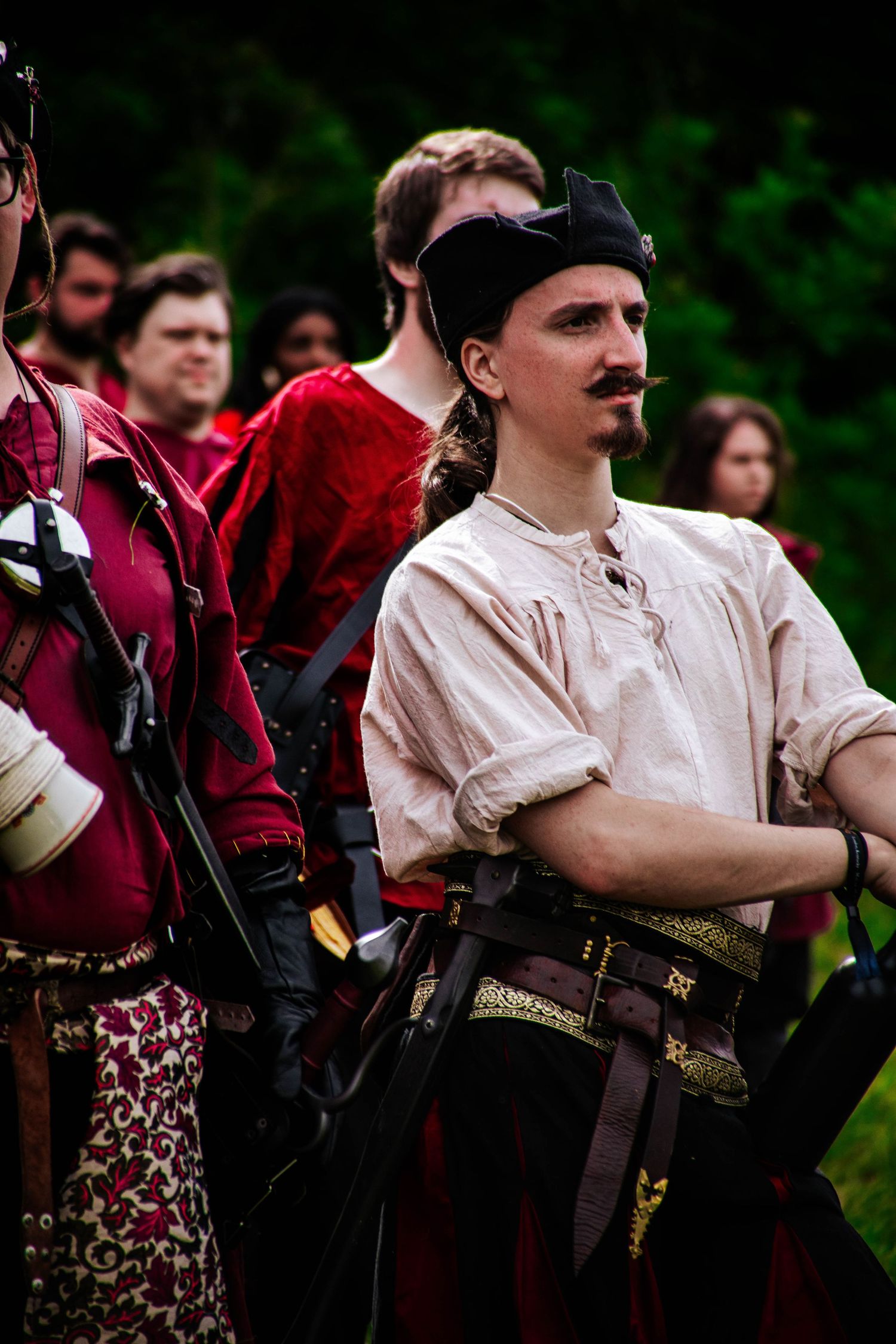 Historical reenactors in period clothing with rifles stand in formation during a military demonstration.